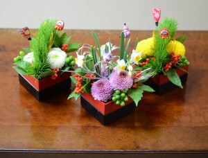 こちらもご好評の、宮内庁御用達 漆器 山田平安堂とのコラボ商品、「花ともえ」(10,800円)。 ピンポンマムと日本水仙や松・千両を添え、新春の喜びを盛り合わせたおせち料理のような趣き
