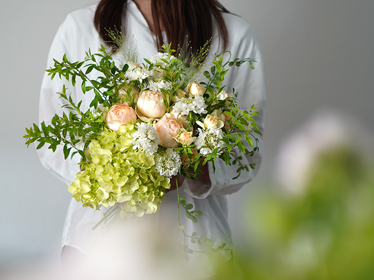 オレンジ色のバラと淡いグリーンのハイドランジアの花束