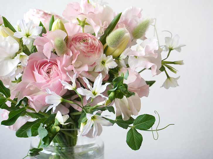 ラナンキュラスとスイートピーの淡いピンクのトーンの花瓶花