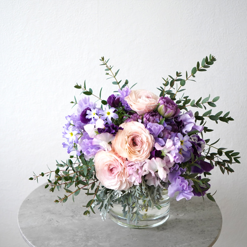 淡いピンクのラナンキュラスと紫の花々を合わせた花瓶花
