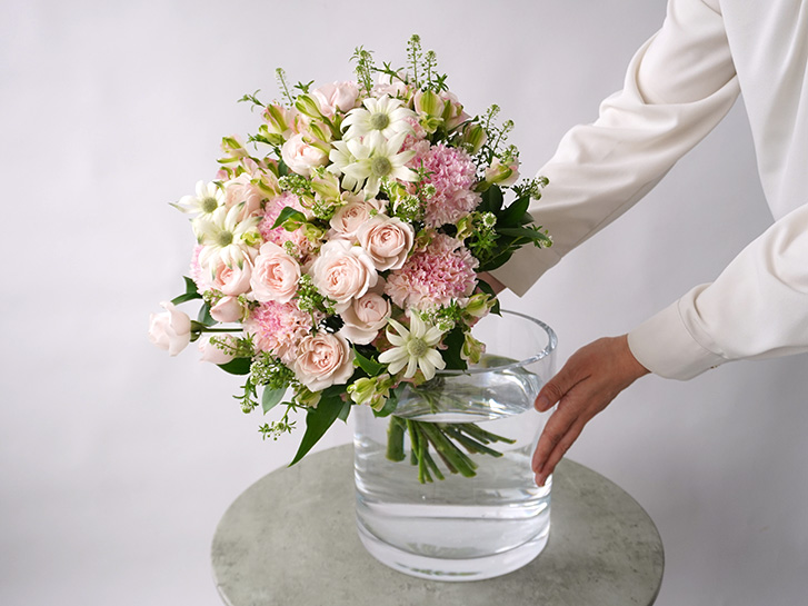 淡いピンクのスプレーバラやカーネーションの花束