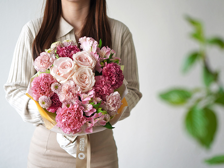 淡いピンクのバラやカーネーションの花束