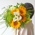 ヒマワリの花束を持つ女性