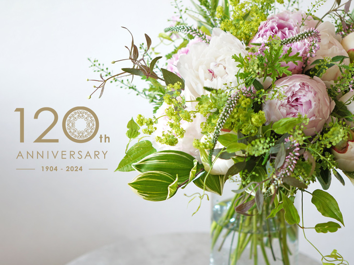 青山花茂120周年ロゴと芍薬の花束